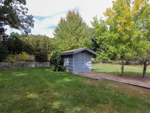 a view of a tree in front of a wooden house