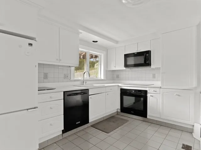 a kitchen with cabinets stainless steel appliances and a window