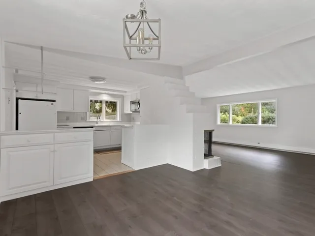 a kitchen with cabinets and wooden floor