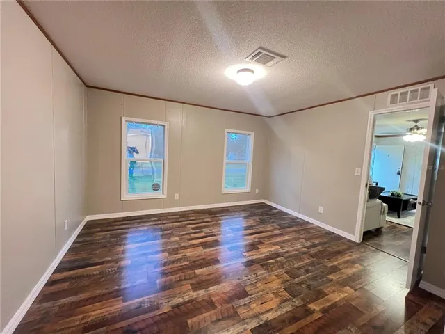 an empty room with wooden floor and window