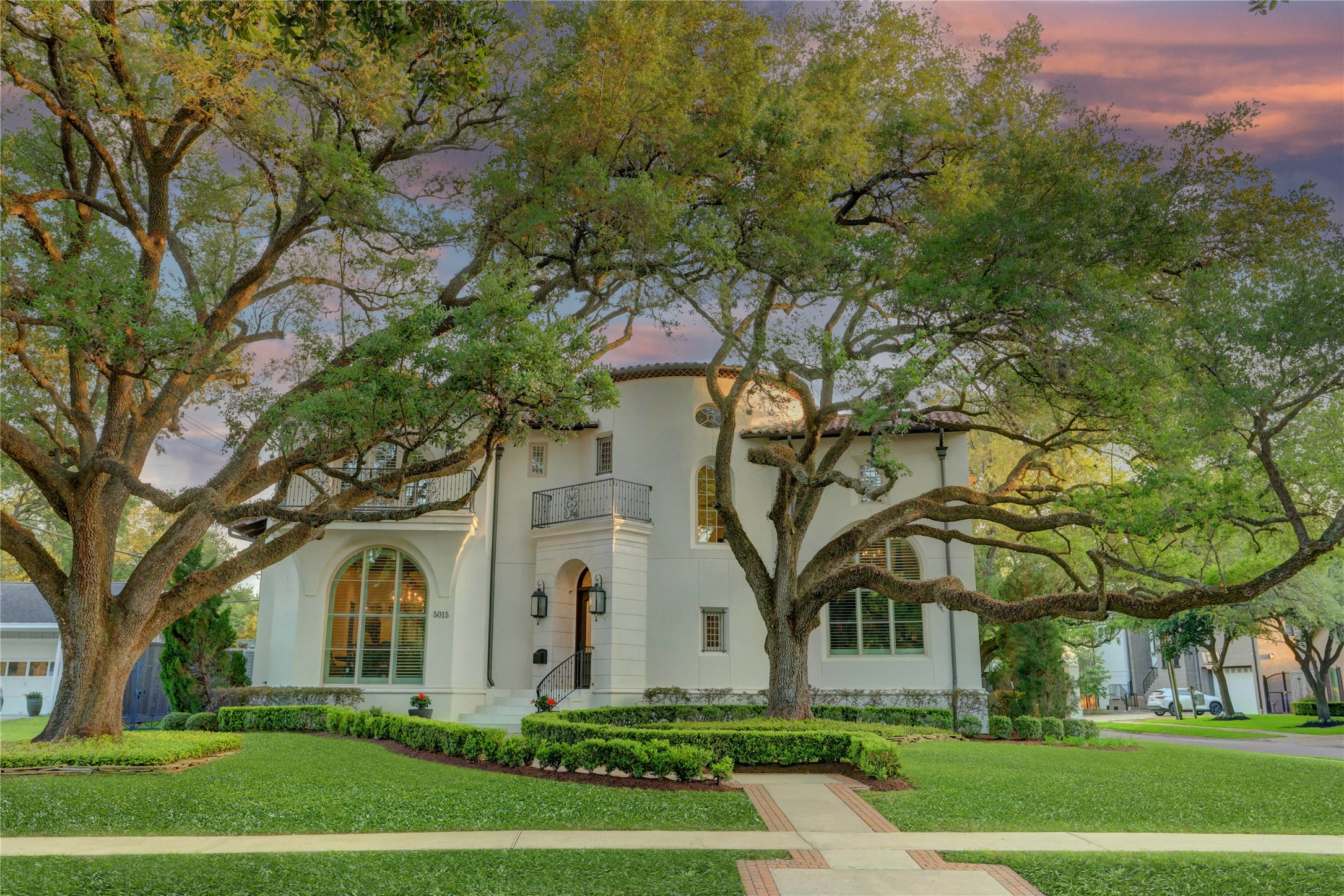 a front view of a house with a yard and trees