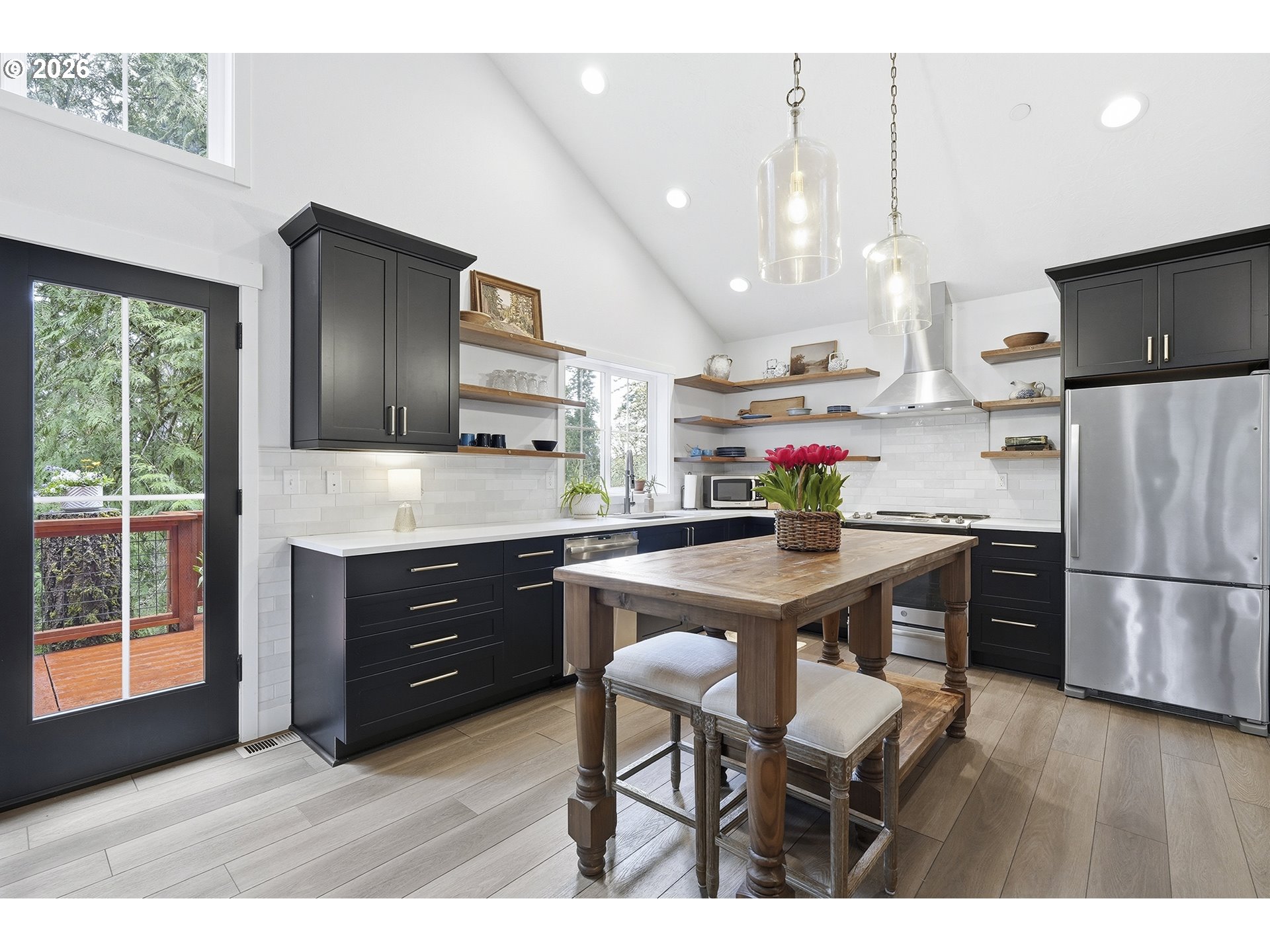 15680 South Wave Road Mulino, OR 97042 - Photo 9 of 43 a kitchen with stainless steel appliances granite countertop a refrigerator a sink dishwasher a stove and a dining table with wooden floor