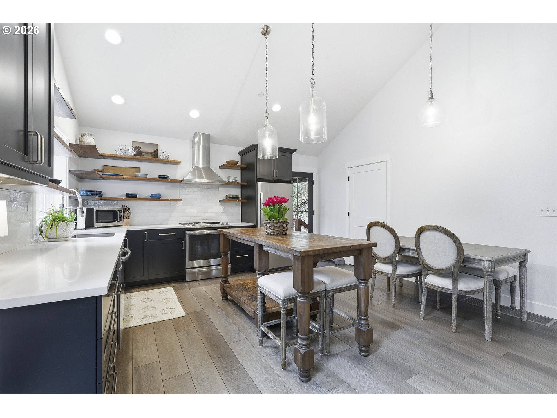 15680 South Wave Road Mulino, OR 97042 - Photo 10 of 43 a kitchen with stainless steel appliances granite countertop a stove a refrigerator a kitchen island a dining table and chairs with wooden floor