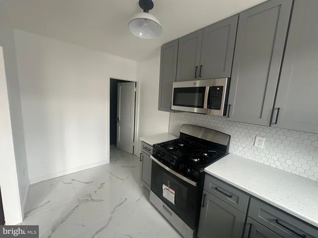 a kitchen with a stove and white cabinets