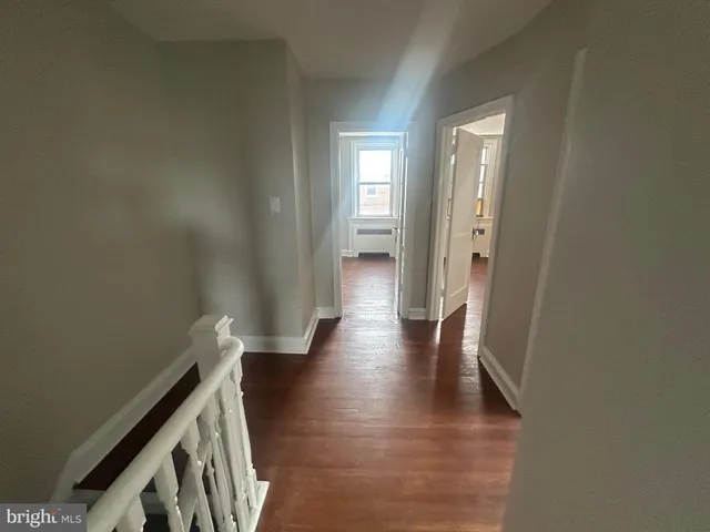a view of a livingroom with wooden floor and a ceiling fan