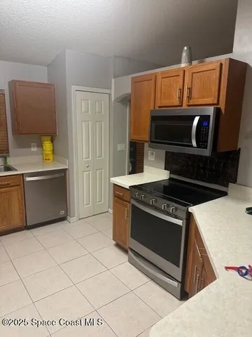 a kitchen with stainless steel appliances a stove a microwave and a sink