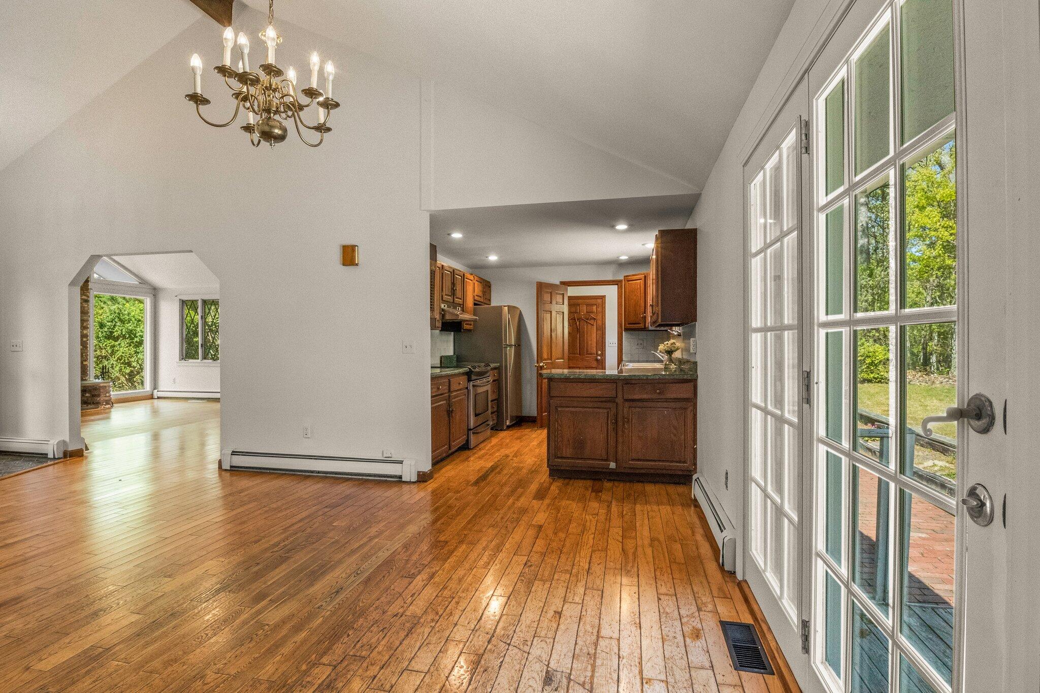 472 Elliott Road Centerville, MA 02632 - Photo 12 of 36 a view of a hallway with wooden floor and a kitchen