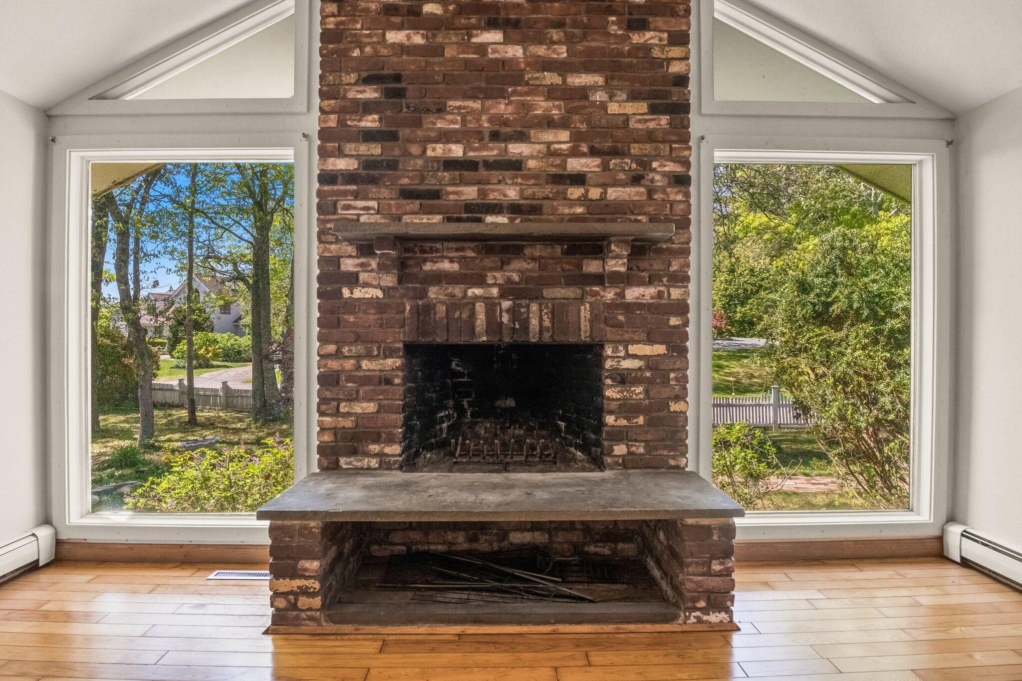 472 Elliott Road Centerville, MA 02632 - Photo 8 of 36 a living room with a fireplace and a floor to ceiling window