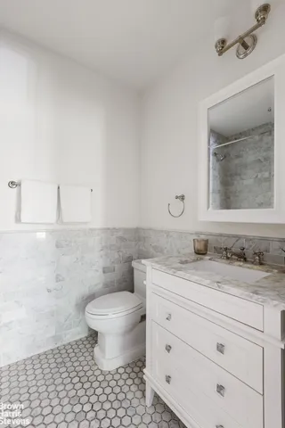 a bedroom with a bed couch and windows