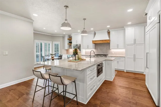 a kitchen with stainless steel appliances granite countertop a white cabinets and a chandelier