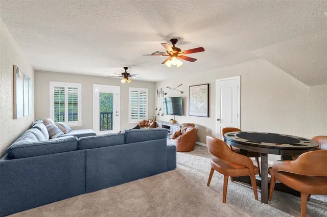 a living room with furniture a ceiling fan and a window
