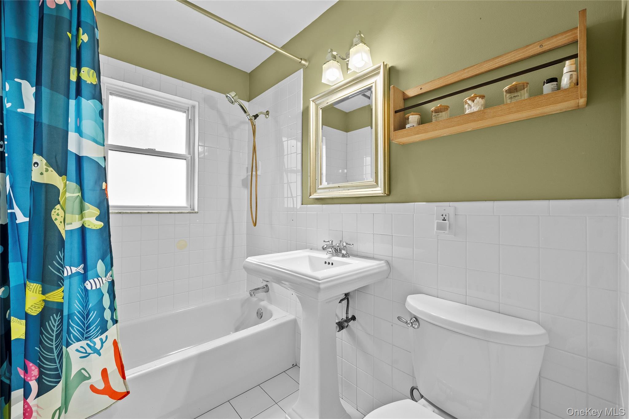 625 Edgewater Road Oakdale, NY 11769 - Photo 28 of 49 Bathroom with shower / tub combo with curtain, tile walls, a wainscoted wall, and tile patterned flooring