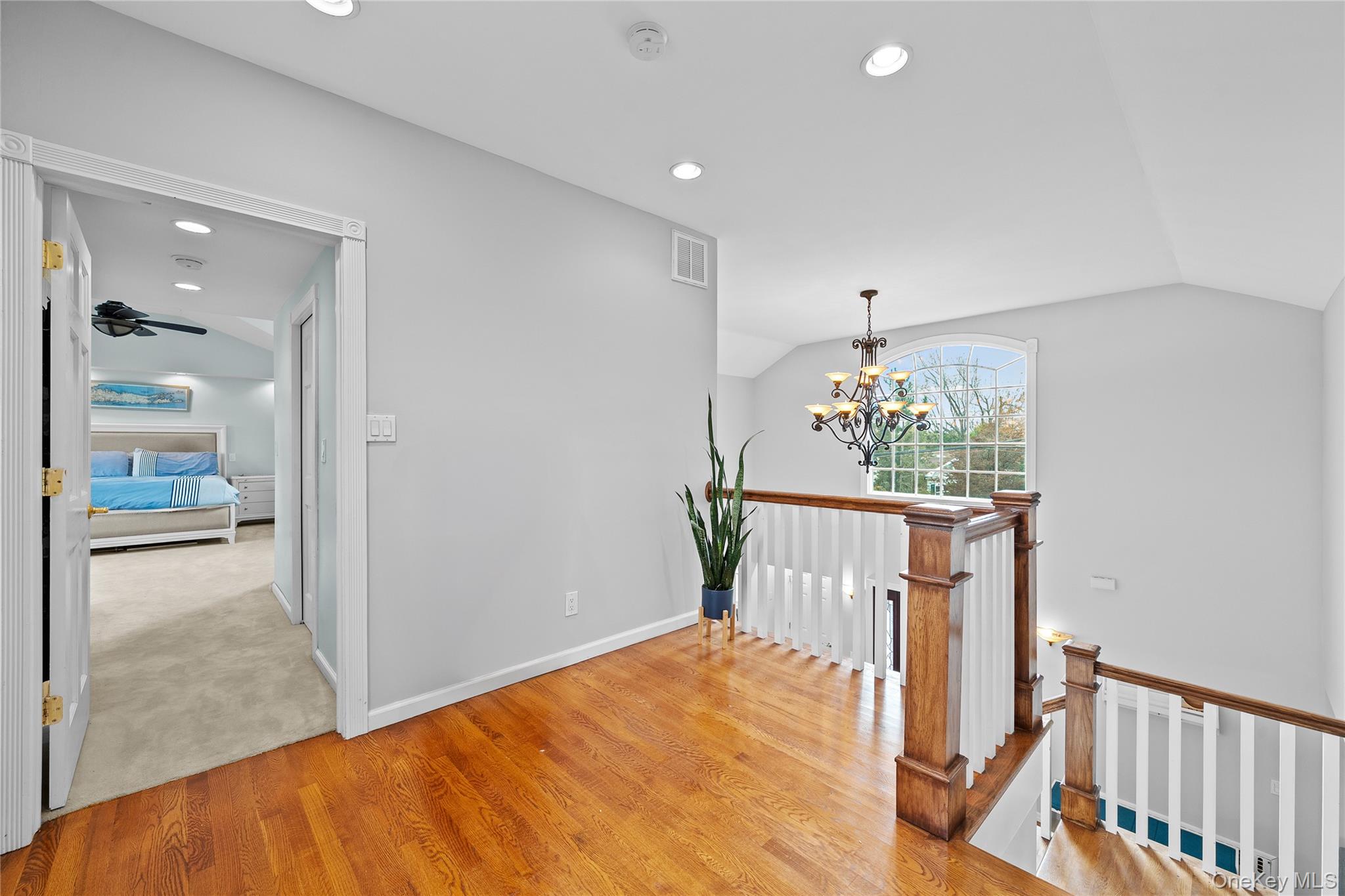 625 Edgewater Road Oakdale, NY 11769 - Photo 30 of 49 Hall with vaulted ceiling, an upstairs landing, light wood-style floors, a chandelier, and recessed lighting
