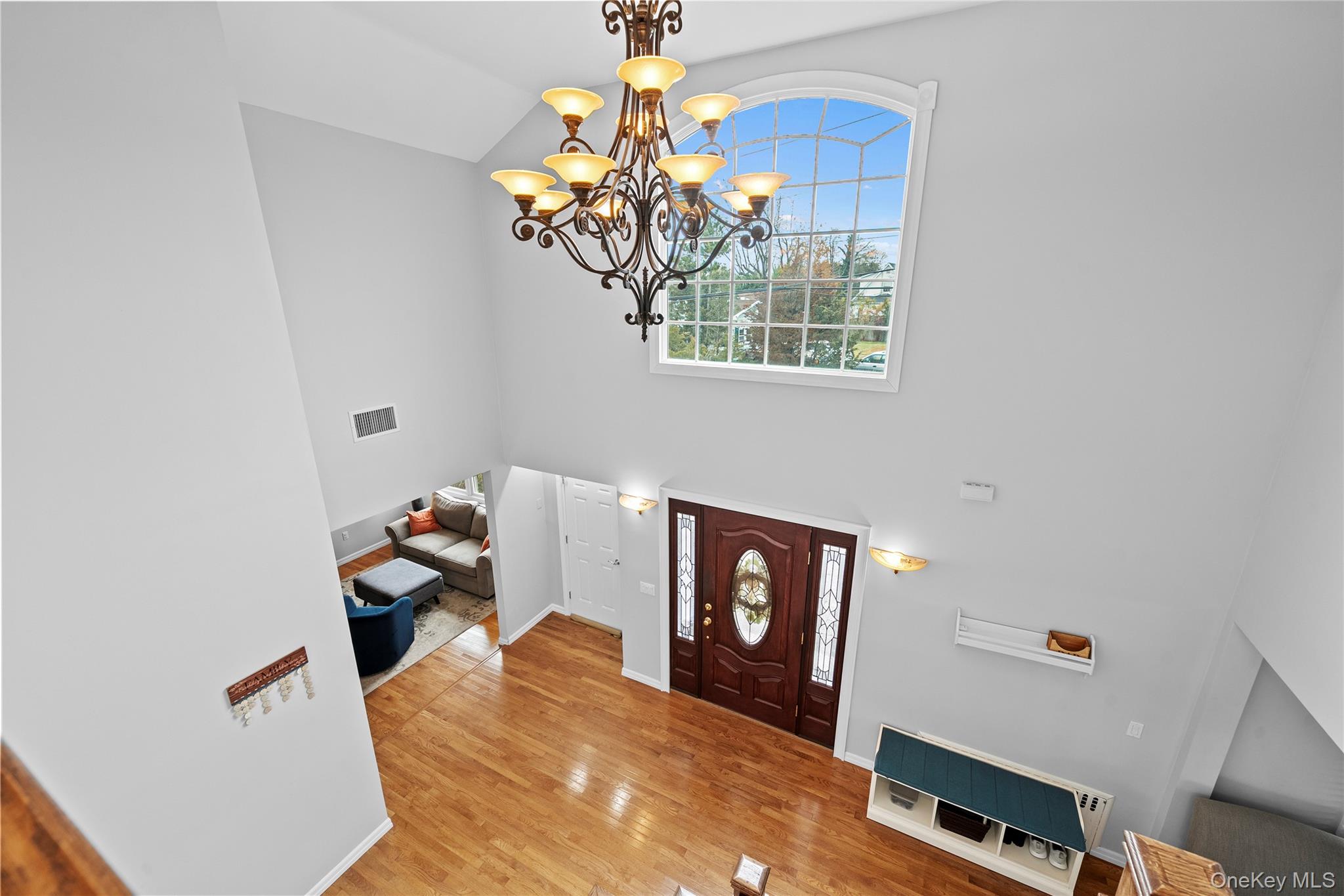 625 Edgewater Road Oakdale, NY 11769 - Photo 31 of 49 Foyer with wood finished floors, a chandelier, and high vaulted ceiling