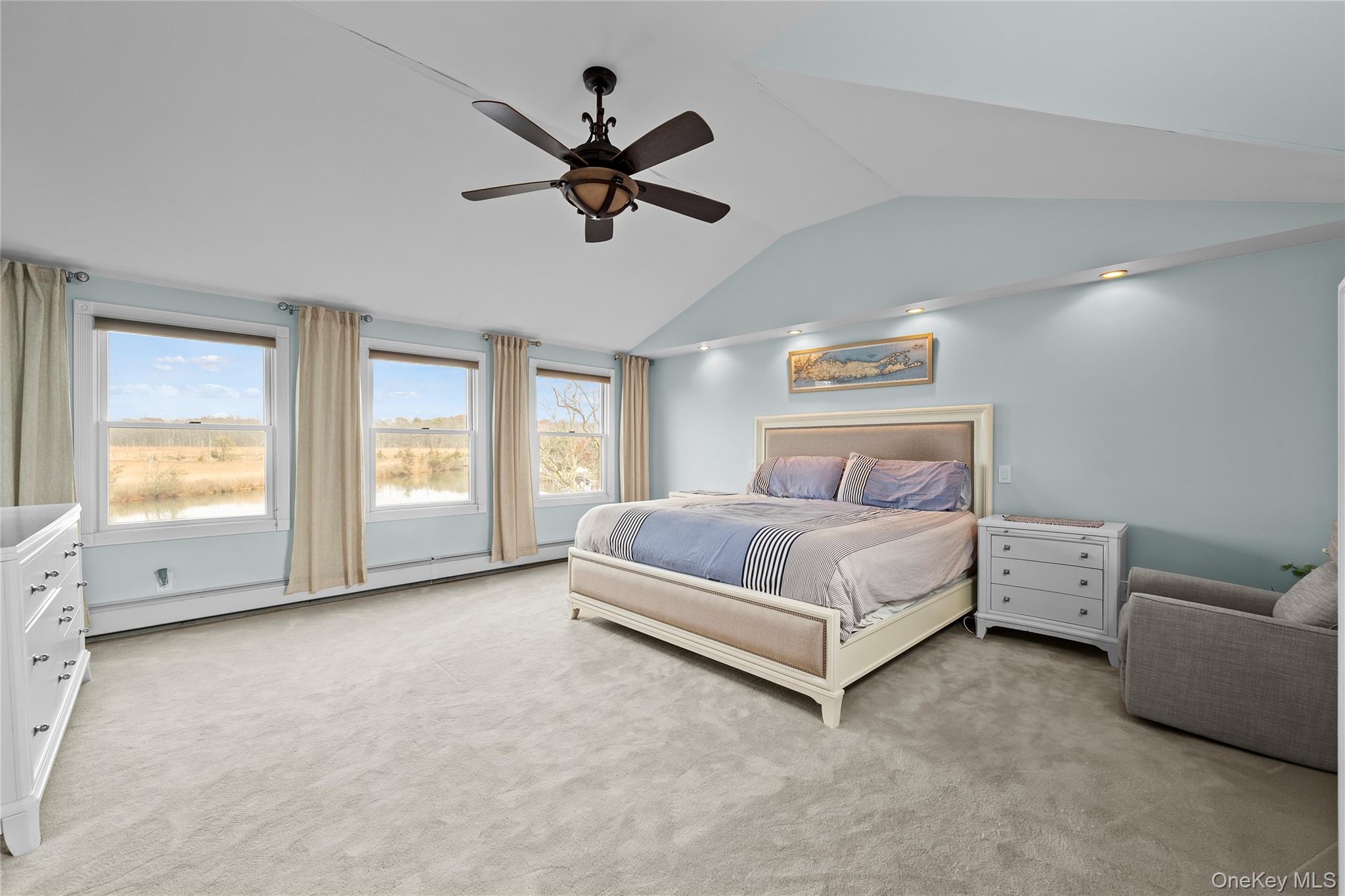 625 Edgewater Road Oakdale, NY 11769 - Photo 32 of 49 Bedroom with light carpet, baseboard heating, lofted ceiling, and ceiling fan