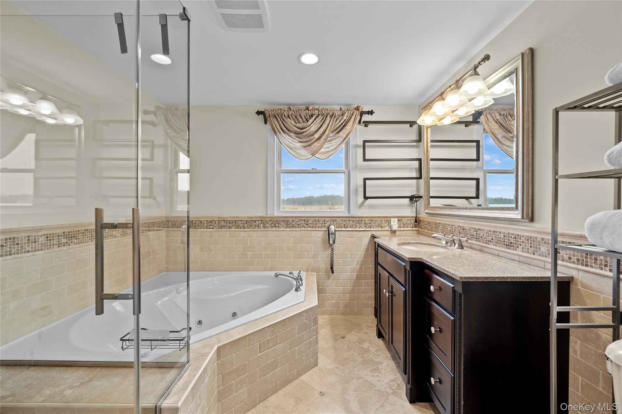 625 Edgewater Road Oakdale, NY 11769 - Photo 35 of 49 Full bath with a jetted tub, vanity, wainscoting, tile walls, and a shower stall