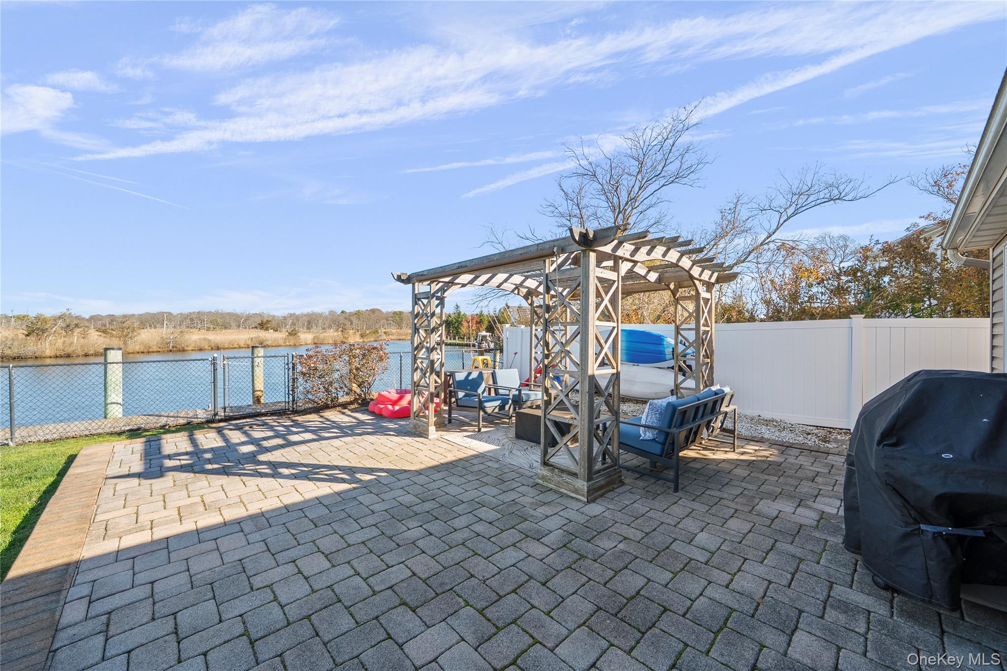 625 Edgewater Road Oakdale, NY 11769 - Photo 42 of 49 Fenced backyard with a patio, a pergola, a grill, and a water view