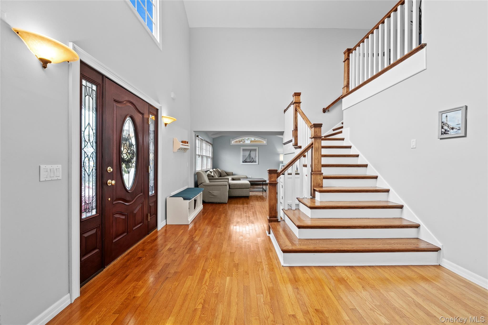 625 Edgewater Road Oakdale, NY 11769 - Photo 6 of 49 Foyer with stairs, light wood-style flooring, and a towering ceiling