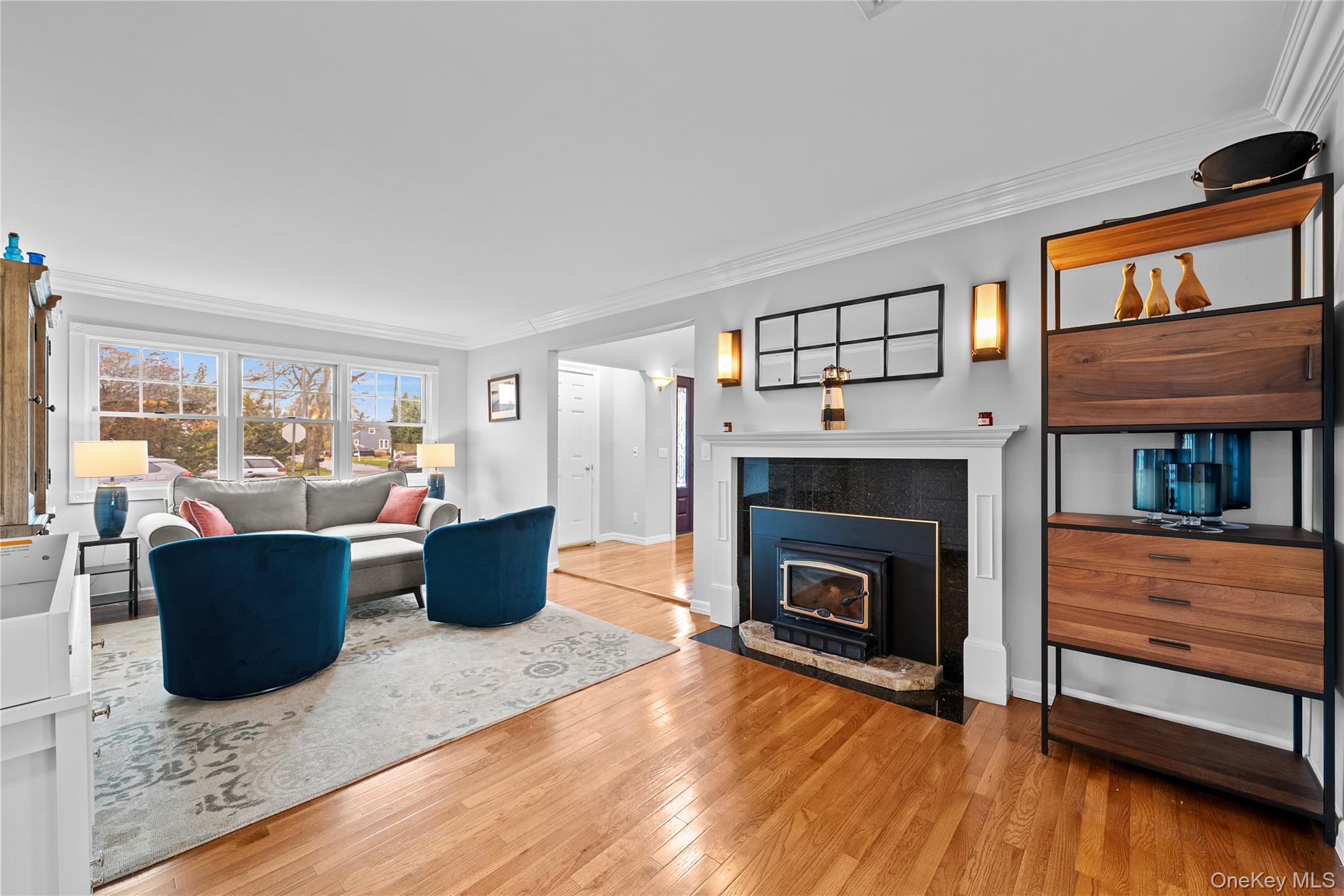 625 Edgewater Road Oakdale, NY 11769 - Photo 9 of 49 Living area with crown molding, light wood-style floors, and a fireplace