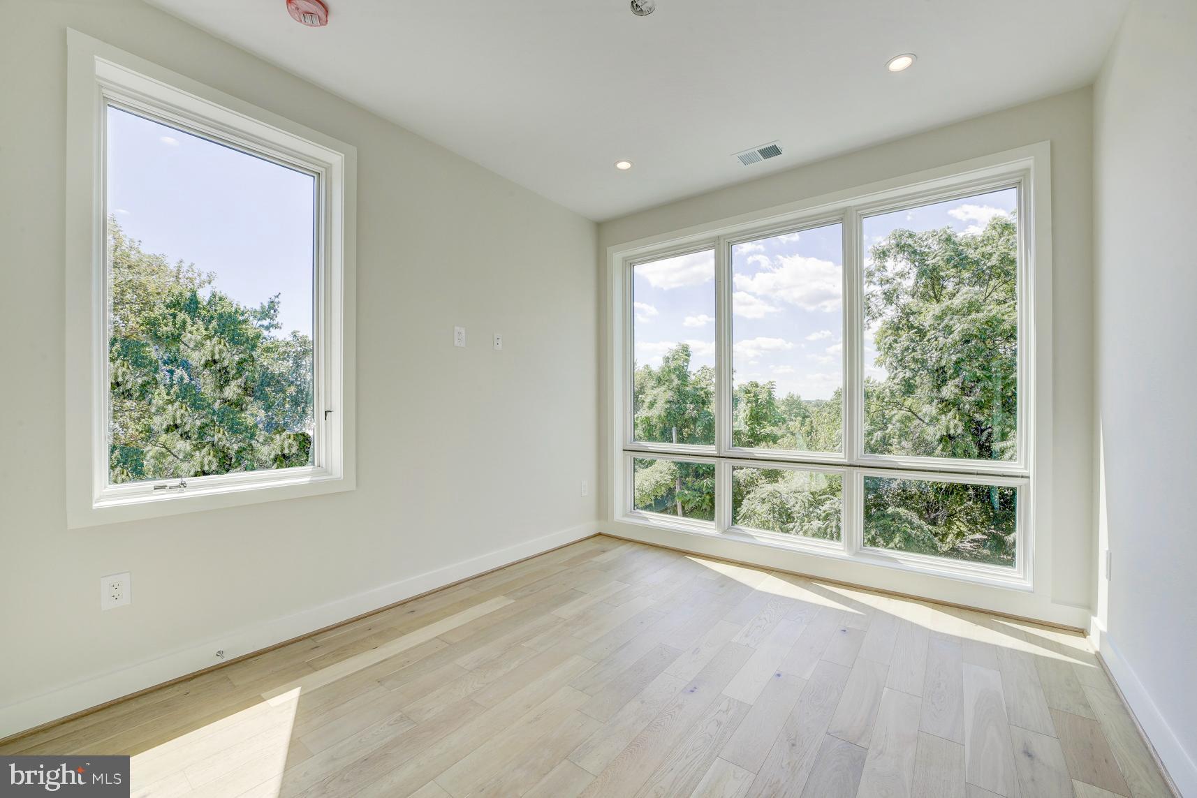 3118 Mt Pleasant Street Northwest, Unit 3 Washington, DC 20010 - Photo 12 of 16 a view of an empty room with wooden floor and a window