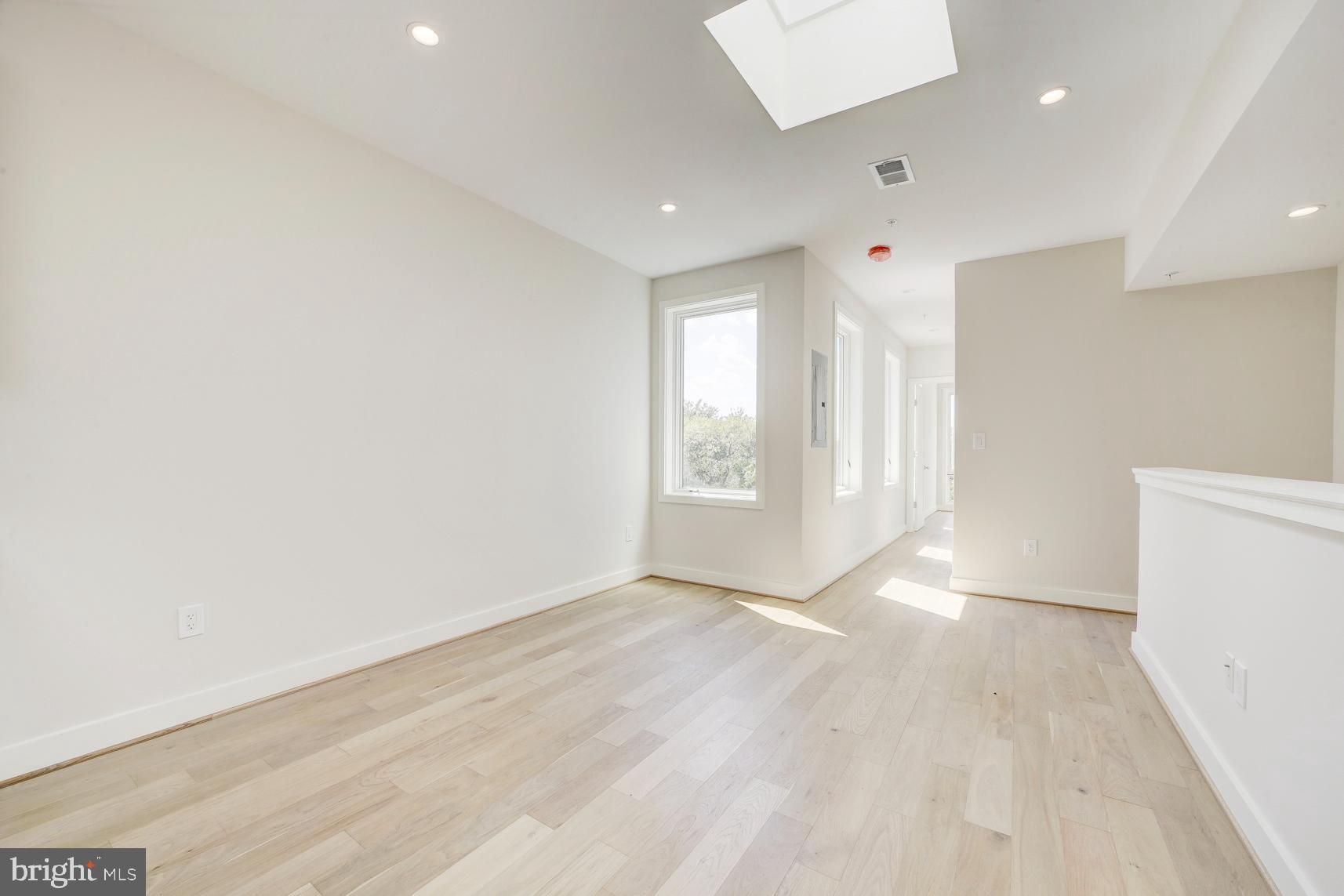 3118 Mt Pleasant Street Northwest, Unit 3 Washington, DC 20010 - Photo 5 of 16 an empty room with wooden floor and windows
