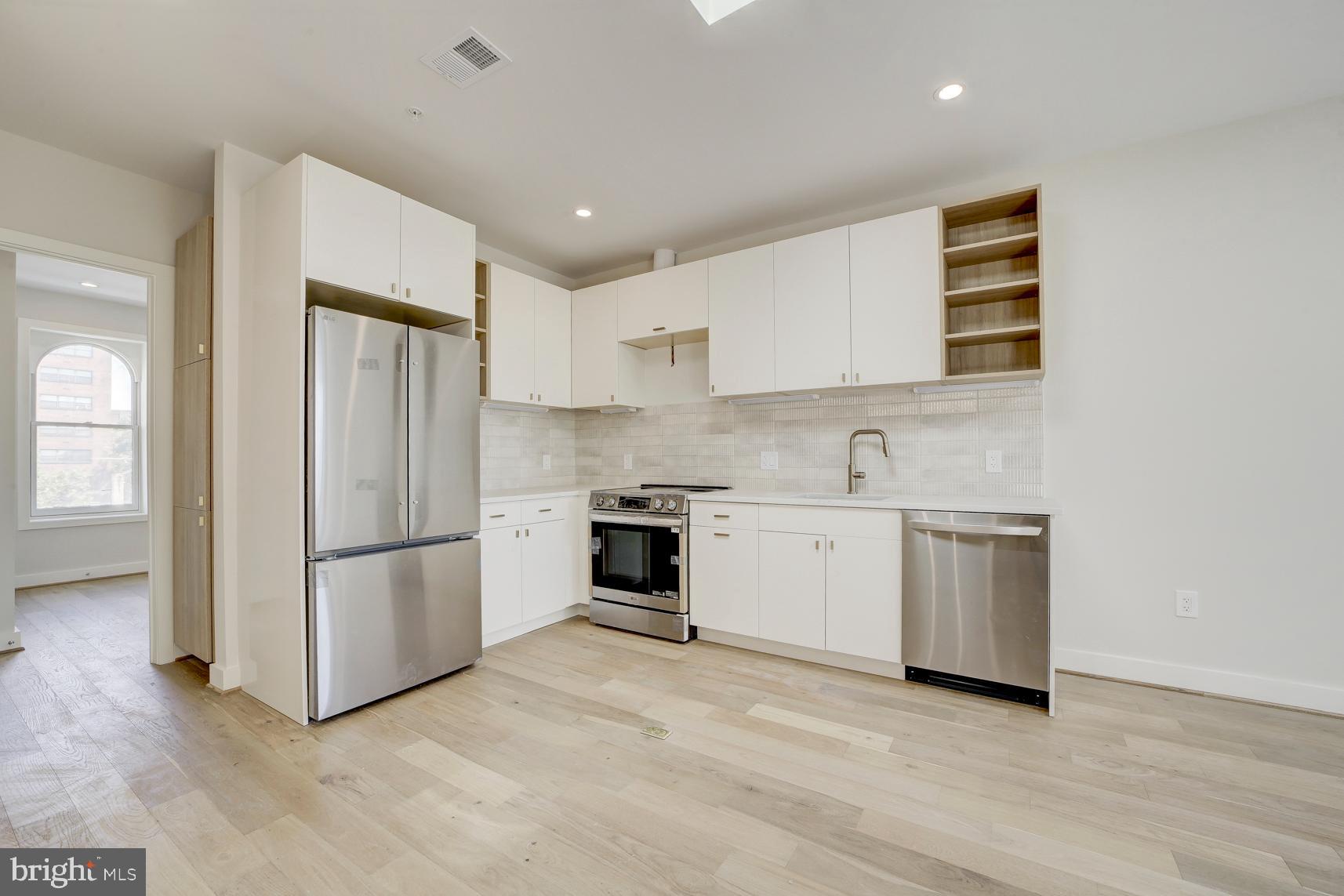 3118 Mt Pleasant Street Northwest, Unit 3 Washington, DC 20010 - Photo 8 of 16 a kitchen with a refrigerator and a stove top oven