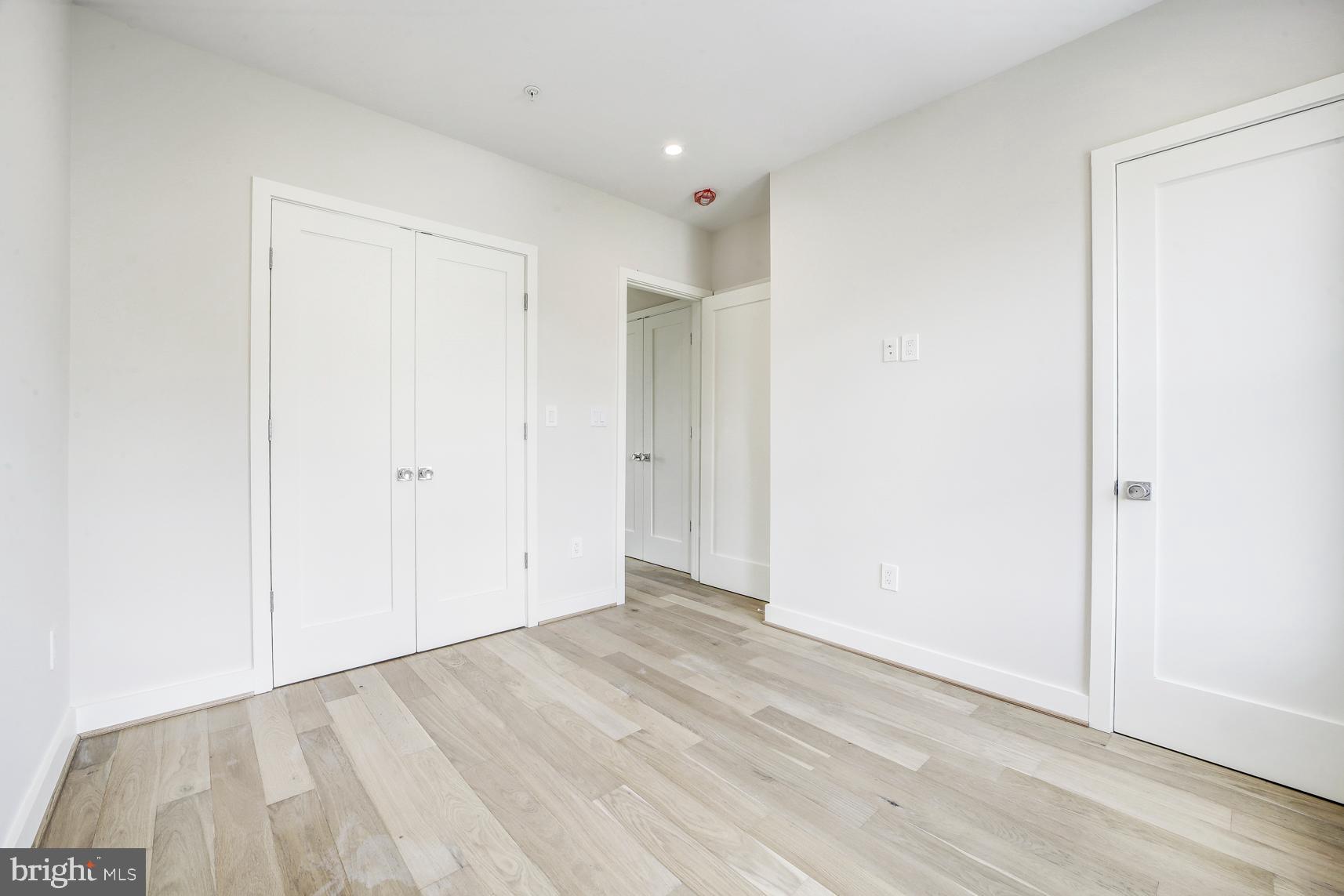 3118 Mt Pleasant Street Northwest, Unit 3 Washington, DC 20010 - Photo 9 of 16 an empty room with wooden floor and closet