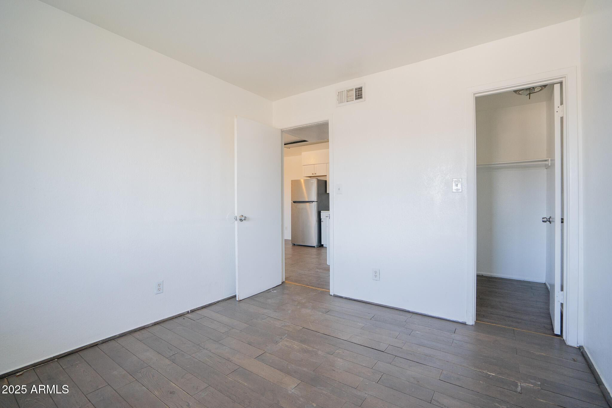 1703 West Mountain View Road, Unit 15 Phoenix, AZ 85021 - Photo 9 of 11 an empty room with wooden floor and closet