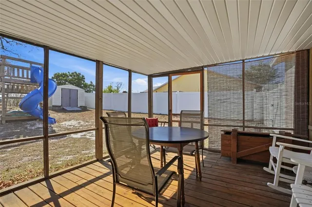 a dining room with furniture and large windows