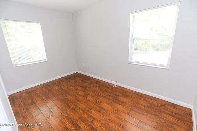 an empty room with wooden floor and a window