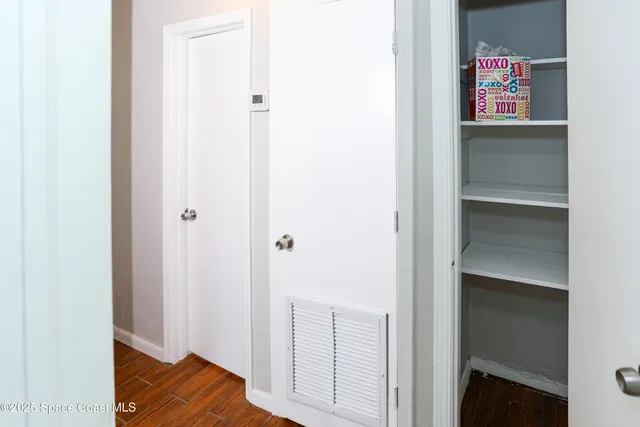 a view of a hallway with wooden floor and closet