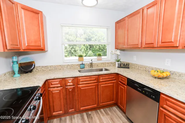 a kitchen with stainless steel appliances granite countertop a sink and a counter space