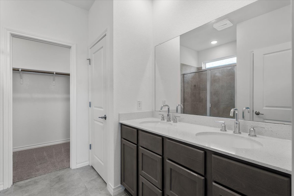 500 Stinchcomb Road Hutto, TX 78634 - Photo 34 of 37 A well-appointed primary bathroom featuring a double vanity with ample storage and a clear view of the adjacent shower.