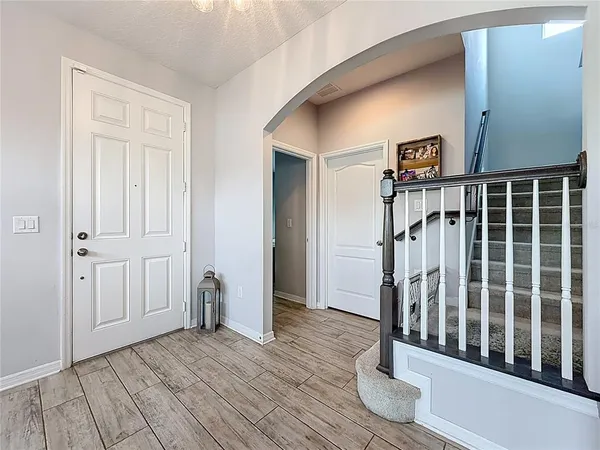 a living room with furniture and a large window with kitchen view