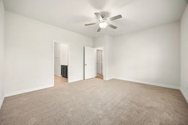 an empty room with closet and fan