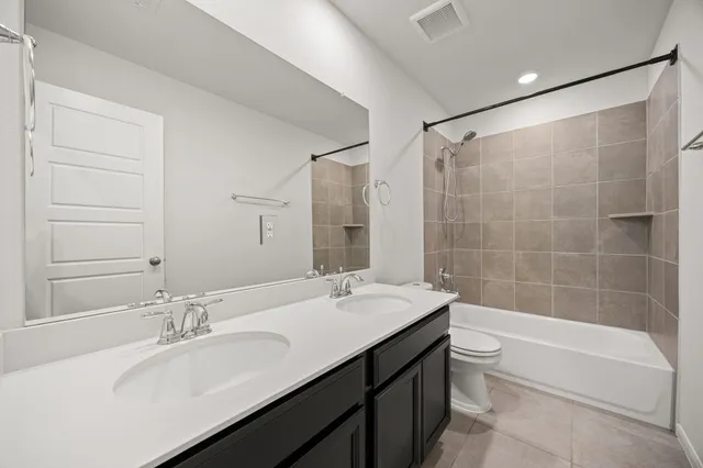 a bathroom with a bathtub shower sink vanity and toilet