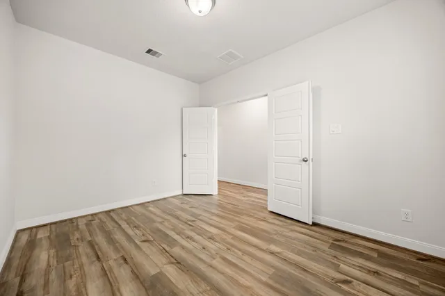 a view of an empty room with wooden floor