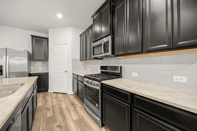 a kitchen with granite countertop stainless steel appliances and wooden cabinets