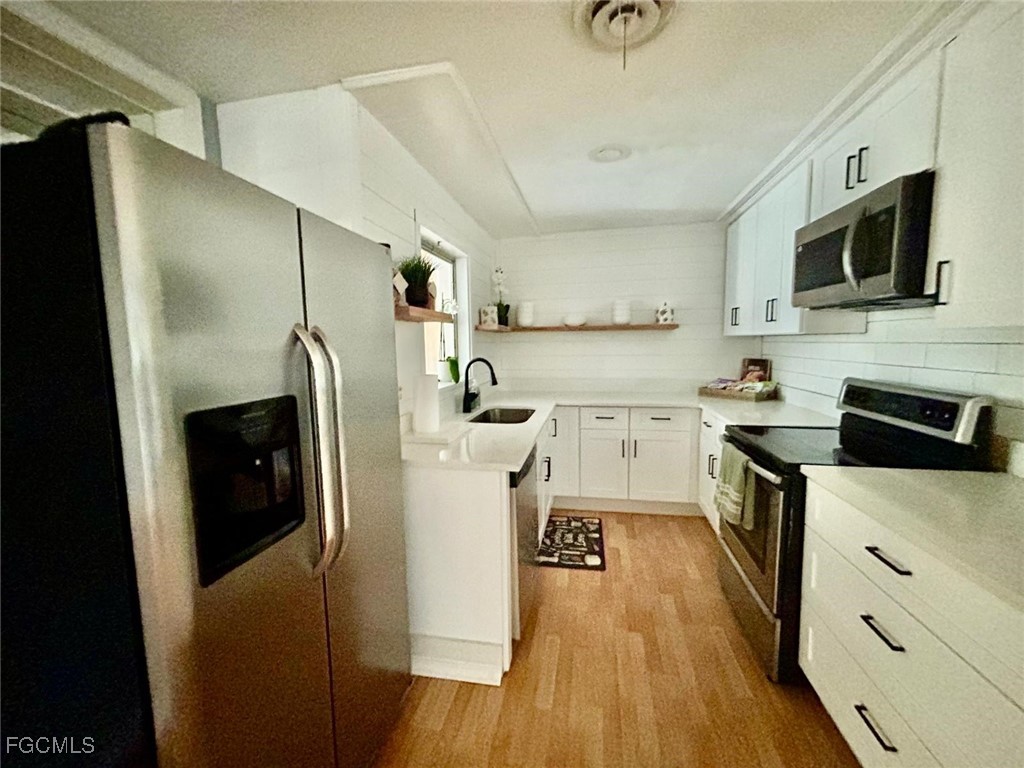 1450 Charles Road Fort Myers, FL 33919 - Photo 5 of 23 a kitchen with stainless steel appliances a refrigerator sink and microwave