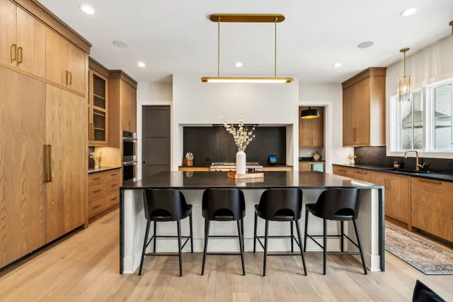 a large kitchen with stainless steel appliances wooden floor and a counter top space