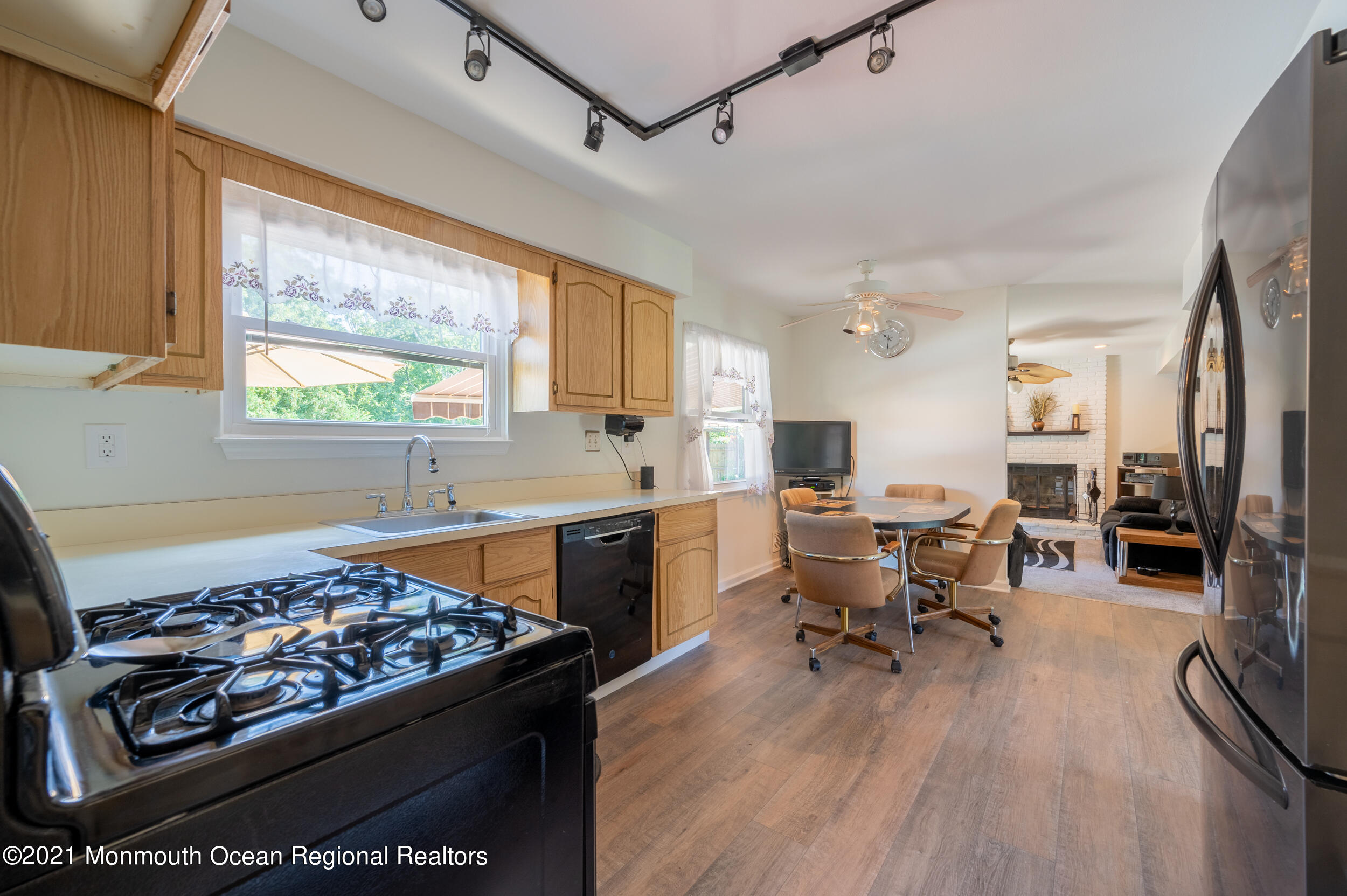 7 New Friendship Road Howell, NJ 07731 - Photo 9 of 26 a kitchen with stainless steel appliances granite countertop a stove top oven a sink dishwasher and a dining table with wooden floor