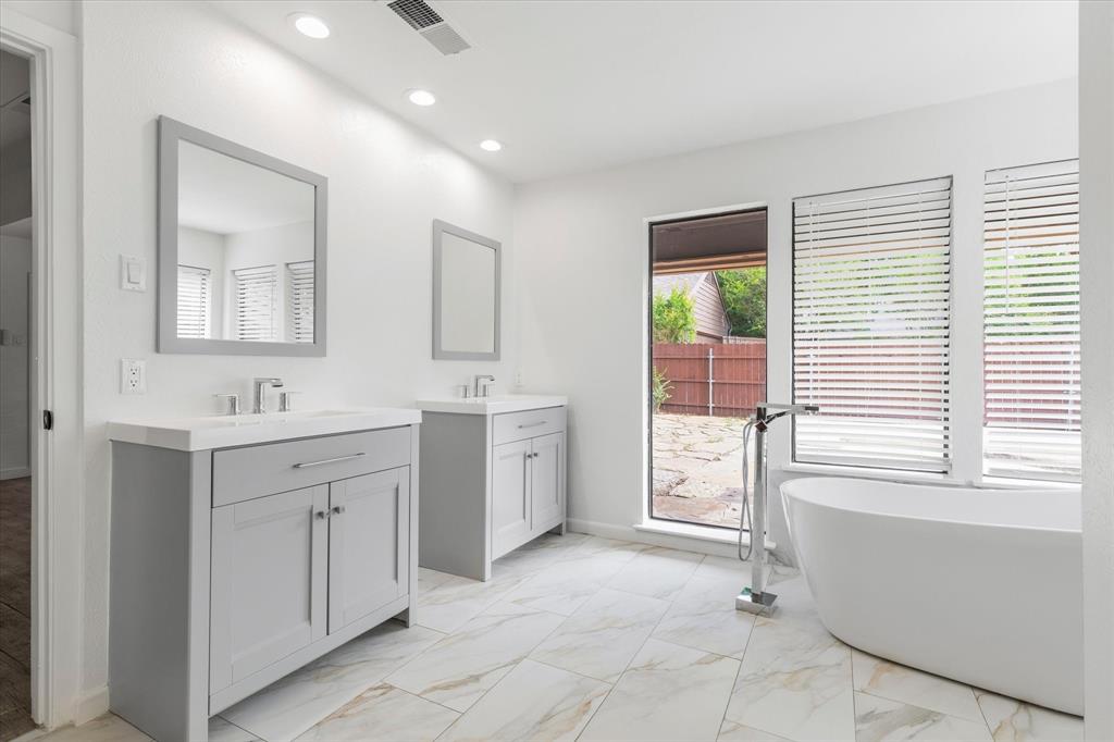 17003 Davenport Road Dallas, TX 75248 - Photo 28 of 40 a spacious bathroom with a double vanity sink a mirror a bathtub and next to a window