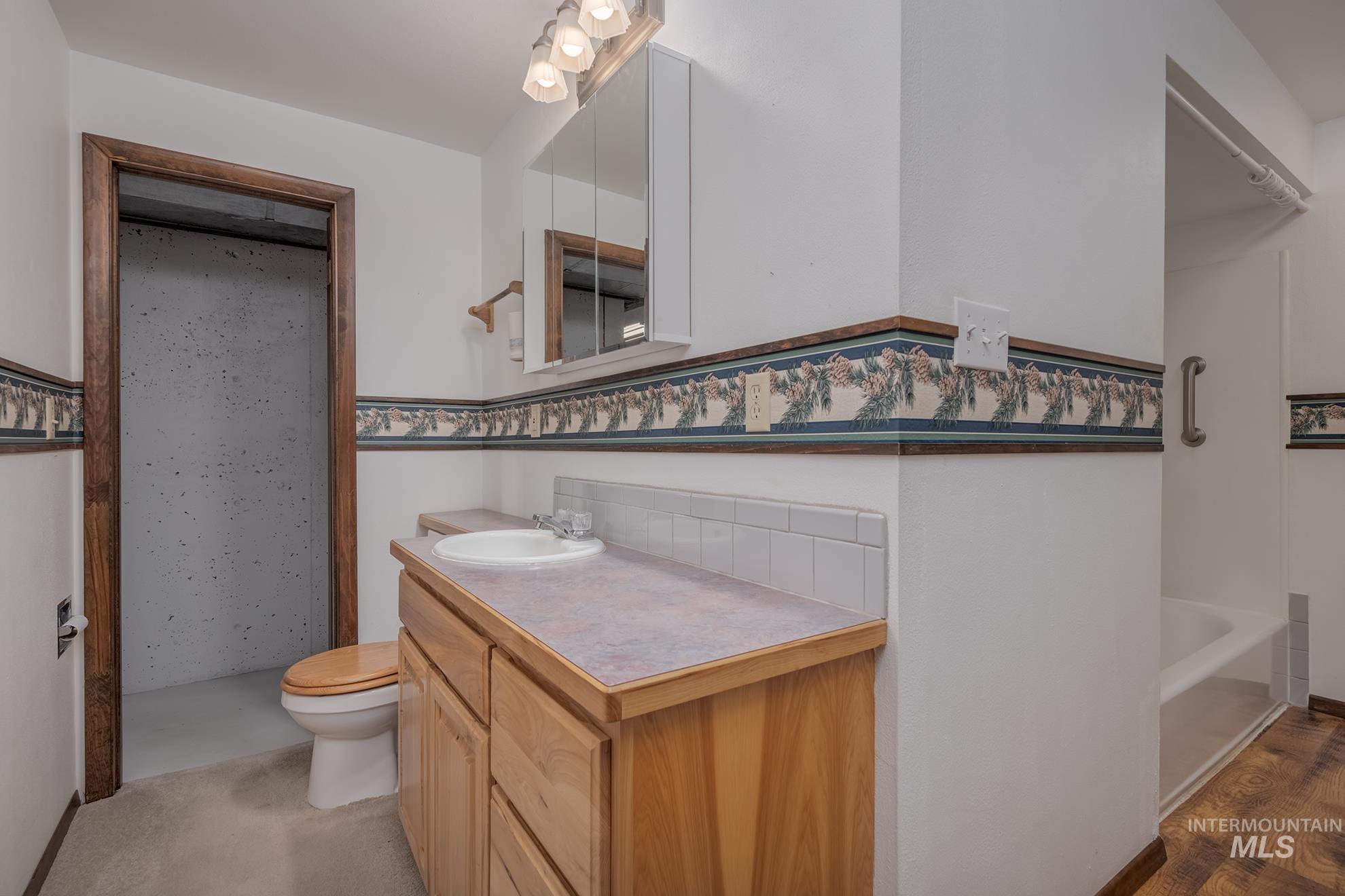 1493 Cove Road Weiser, ID 83672 - Photo 28 of 50 Bathroom featuring a wood-finish vanity with an integrated sink, a tiled backsplash, and a wall-mounted medicine cabinet