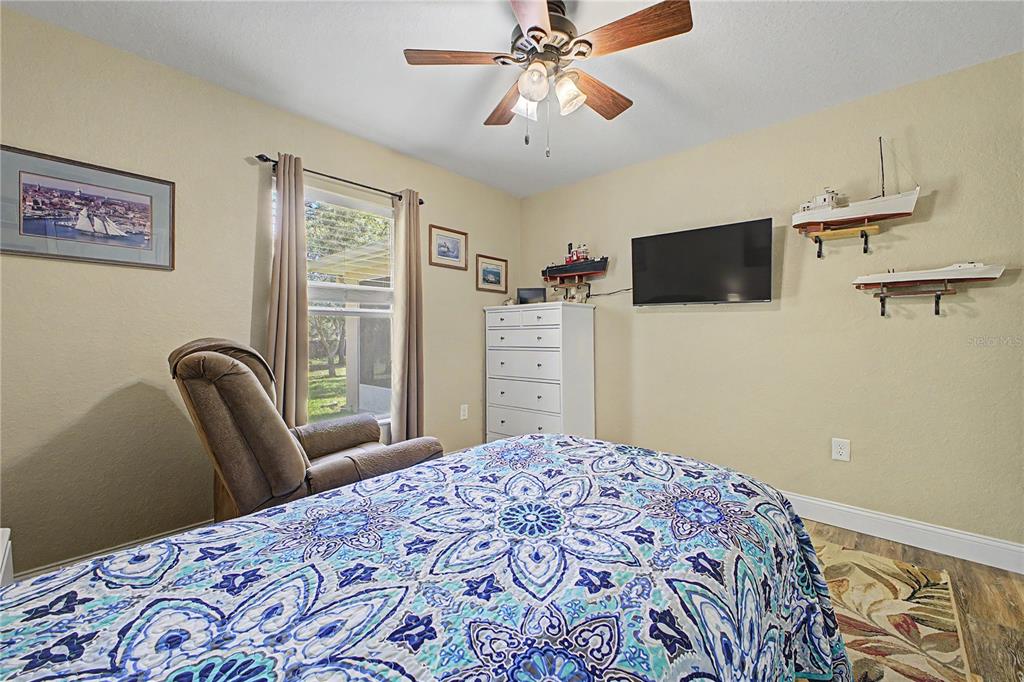 11213 Flock Avenue Weeki Wachee, FL 34613 - Photo 29 of 46 a bedroom with a bed and a flat screen tv