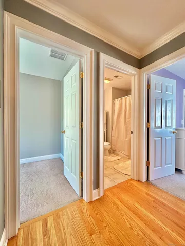 a view of a bedroom with wooden floor and bathroom