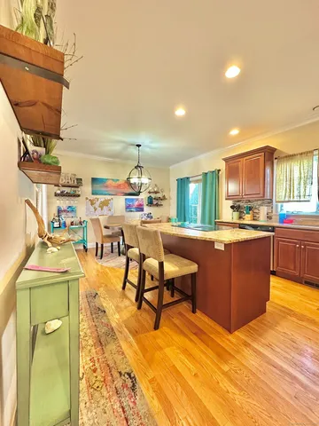 a living room with a couch and a dining table with wooden floor