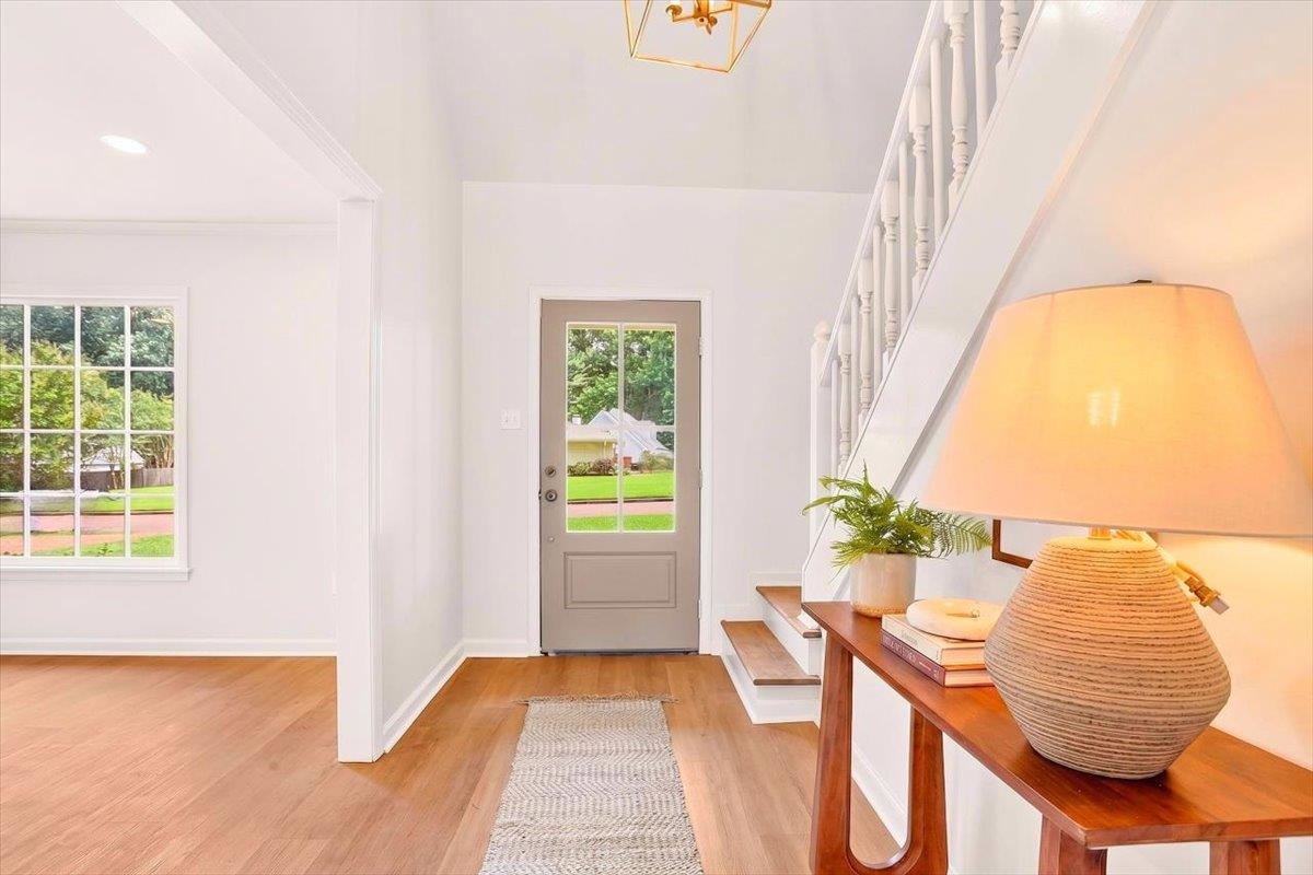 7674 Apple Valley Road Germantown, TN 38138 - Photo 2 of 15 Entryway featuring a glass-paneled door, high ceilings, wood-finish flooring, a baluster staircase, and a gridded window