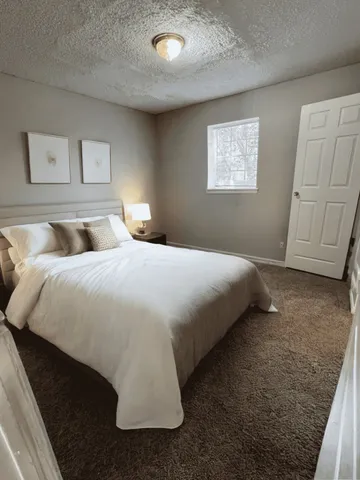 a bedroom with a bed and painting on the wall