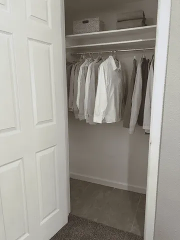 a view of walk in closet with clothes and shoes