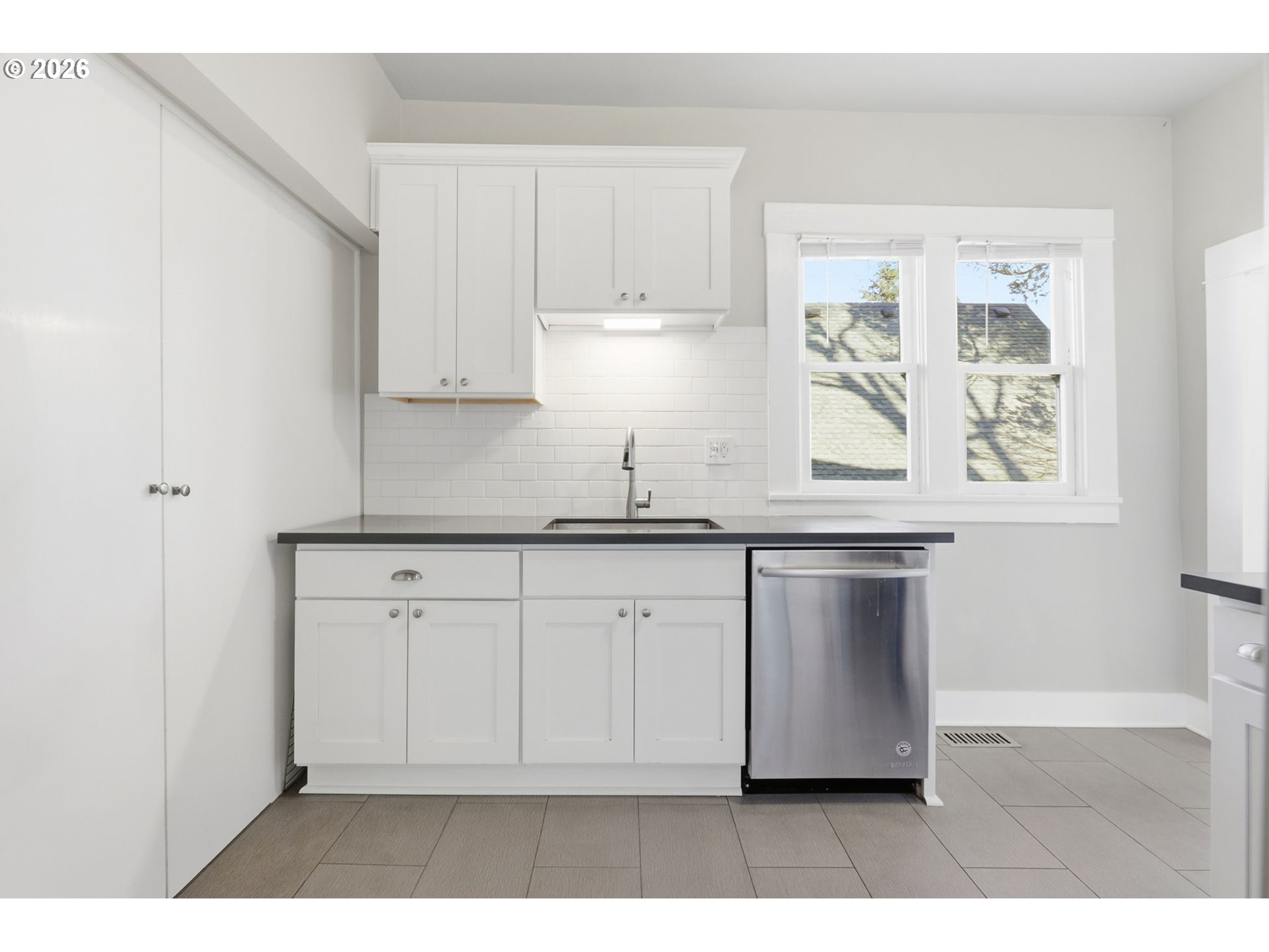 25 Southeast 76th Avenue Portland, OR 97215 - Photo 19 of 48 a kitchen with granite countertop white cabinets and black appliances